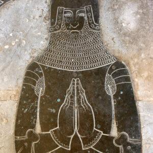 A medieval figure depicted in a monumental brass