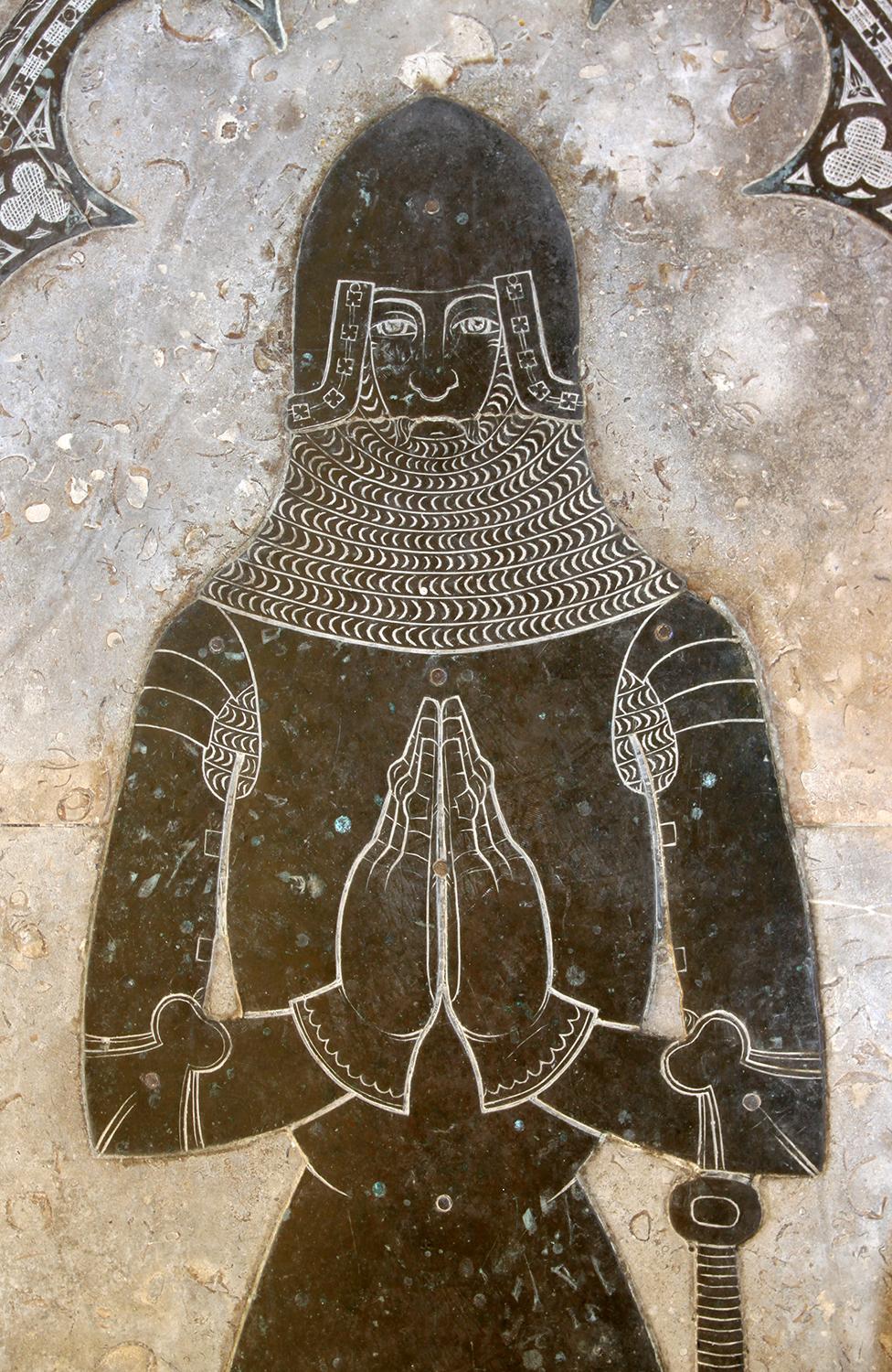 A medieval figure depicted in a monumental brass